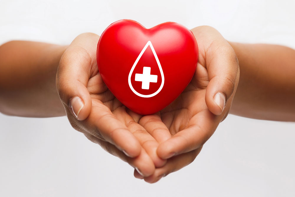 Two hands holding a plastic red heart